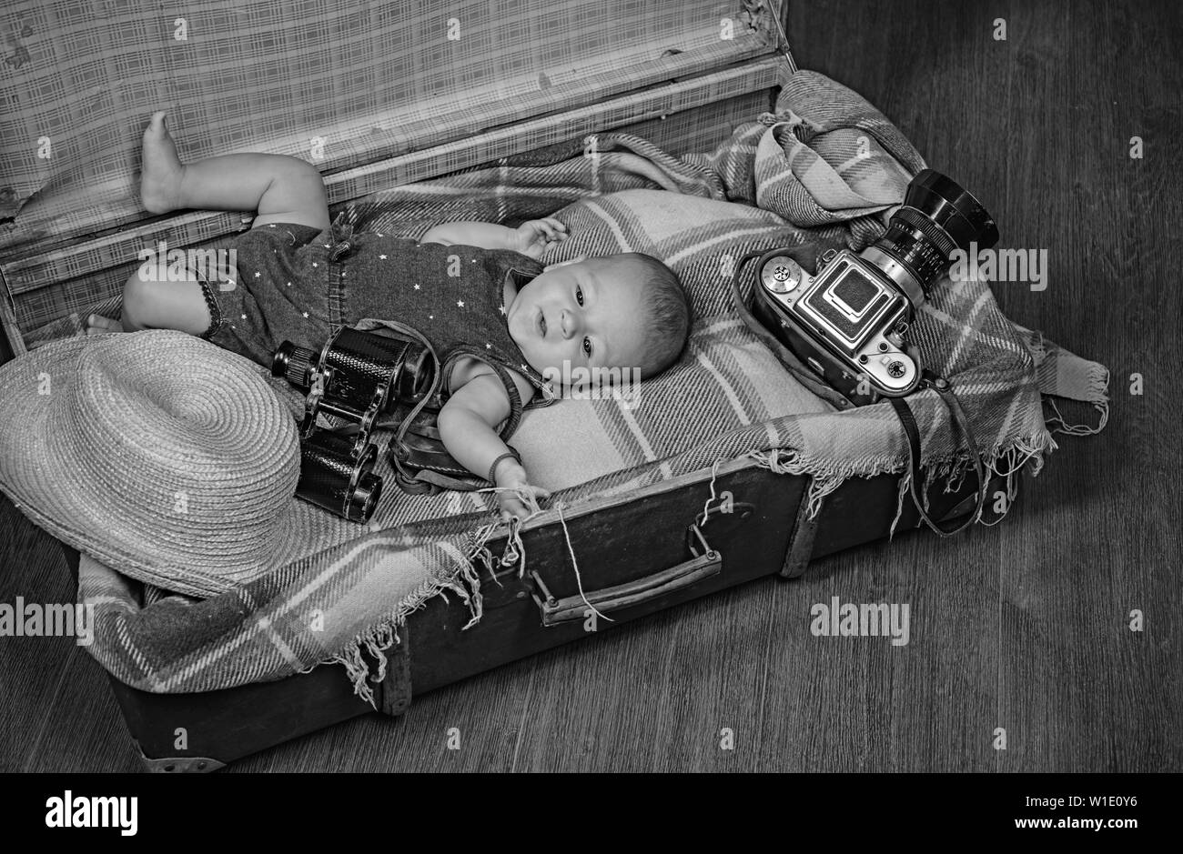 How does this thing turns on. Family. Child care. Small girl in suitcase. Traveling and adventure. Sweet little baby. New life and birth. Portrait of Stock Photo