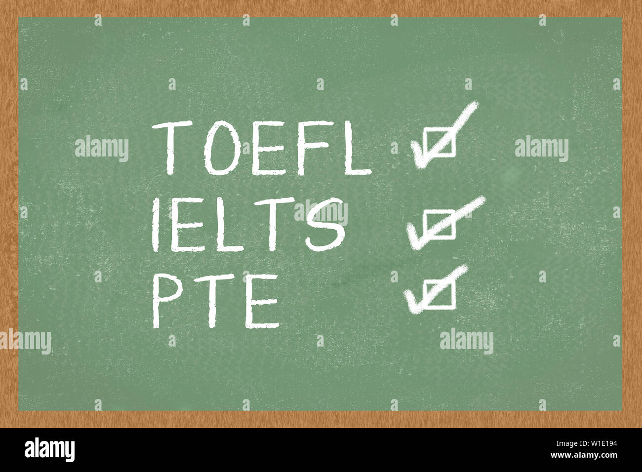 Word TOEFL, IELTS, PTE , with boxes to tick on green Chalkboard background. Test of English as a Foreign Language exams Stock Photo