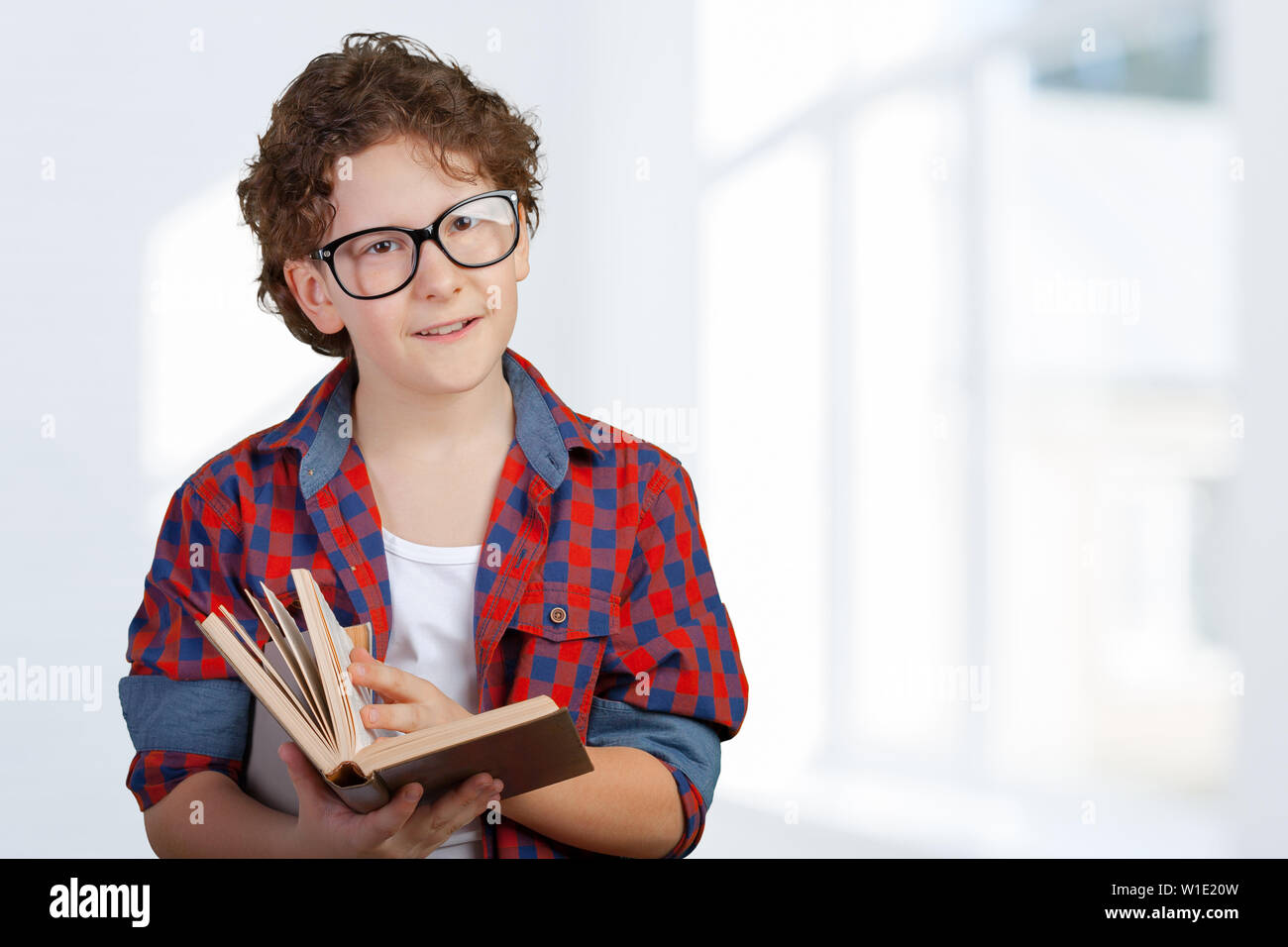 cute elementary school boy holding book Stock Photo - Alamy