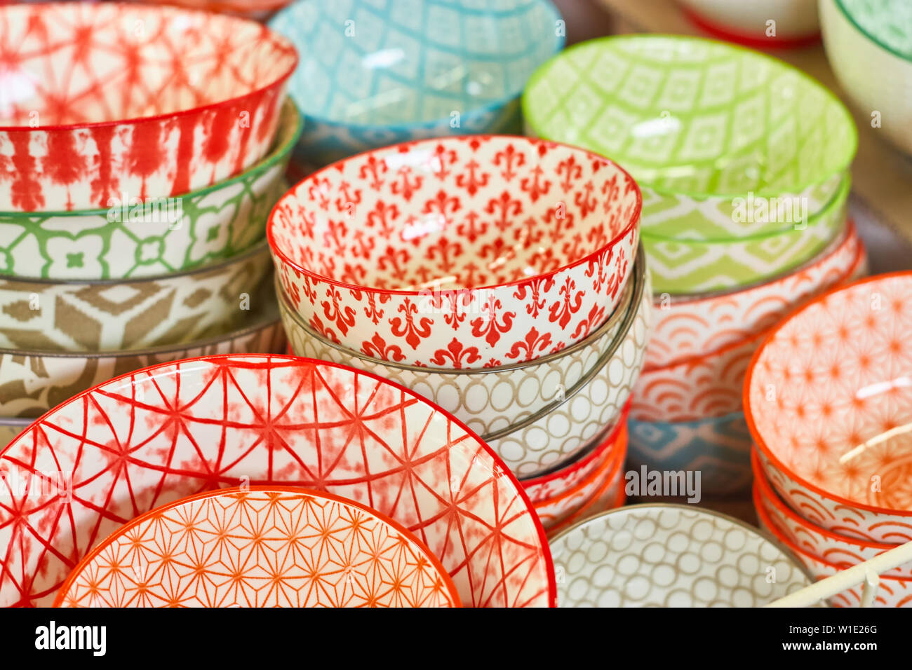 Group of ceramic bowls in the store. Dishes with different colorful patterns. Stock Photo