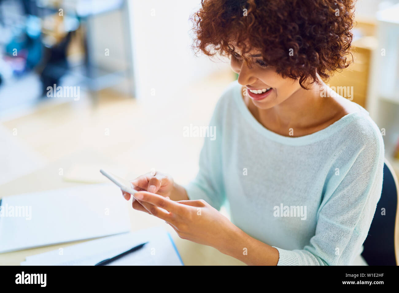 Happy young woman using her smartphone - selective focus Stock Photo