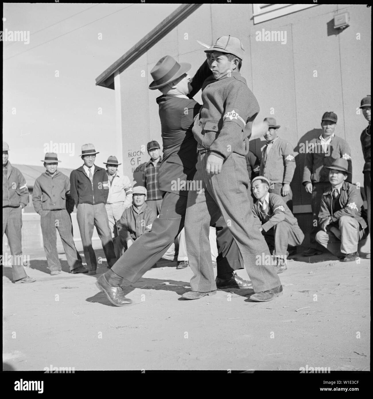Granada Relocation Center, Amache, Colorado. Chief of Internal Security, Tomlinson, demonstrates to . . .; Scope and content:  The full caption for this photograph reads: Granada Relocation Center, Amache, Colorado. Chief of Internal Security, Tomlinson, demonstrates to a class of volunteer civilian police, the art of handling a knife attack. Tomlinson hold regular classes instructing his force in the mehanics of good police work. Stock Photo