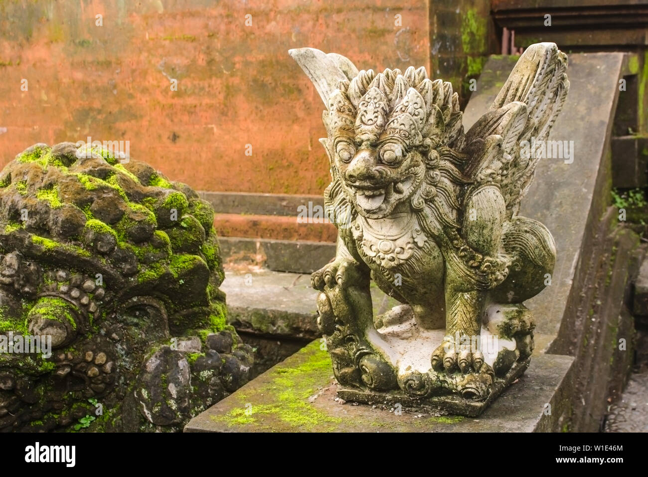 Close up of a mossy gray stone sculpture of Garuda legendary bird at Ubud Palace. Carved in traditional Balinese style. Stock Photo