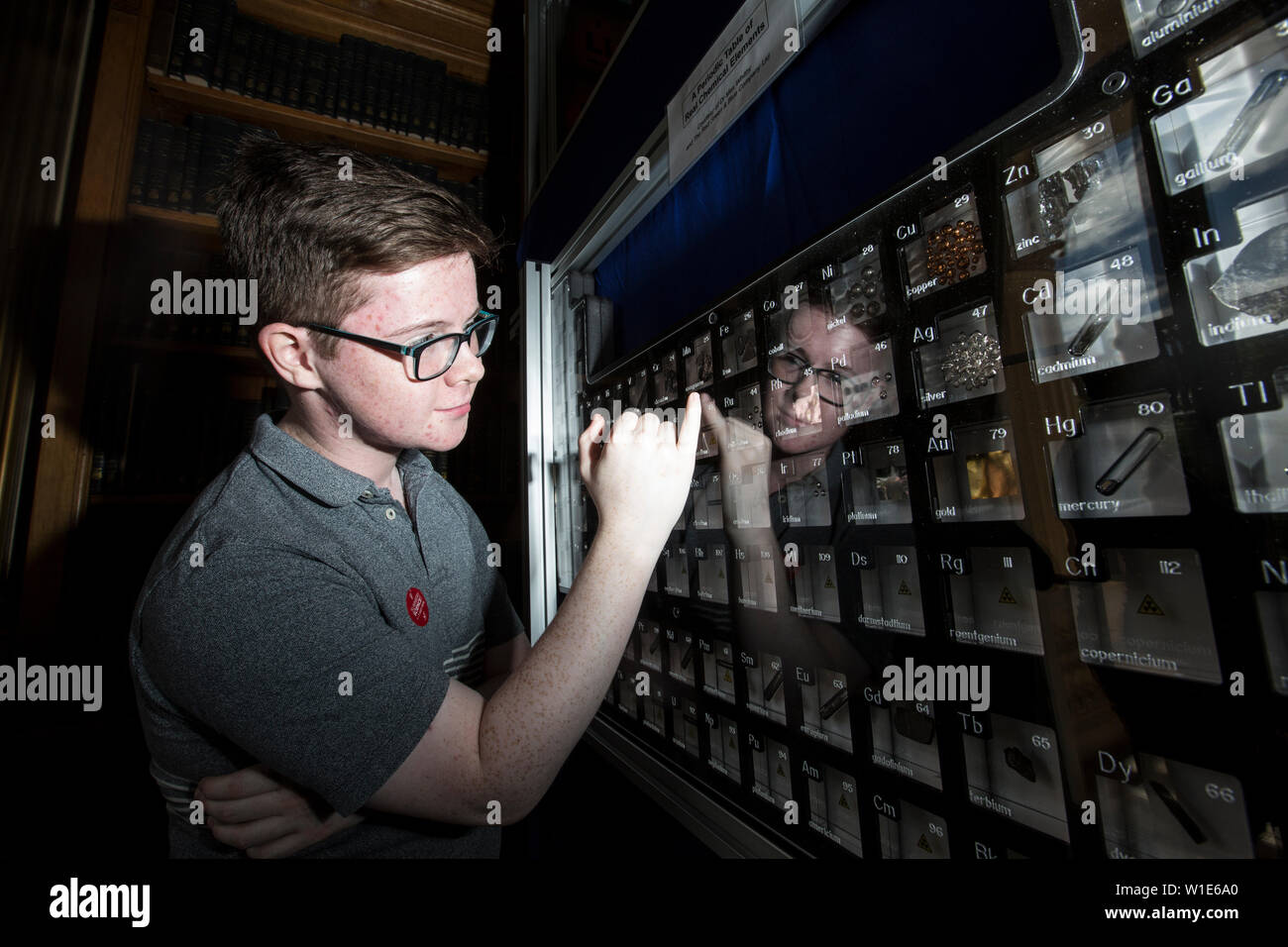Royal Society Summer Science Exhibition, a young man looking at a Periodic Table of Real Chemical Elements, celebrating the 150th anniversary in London. Stock Photo