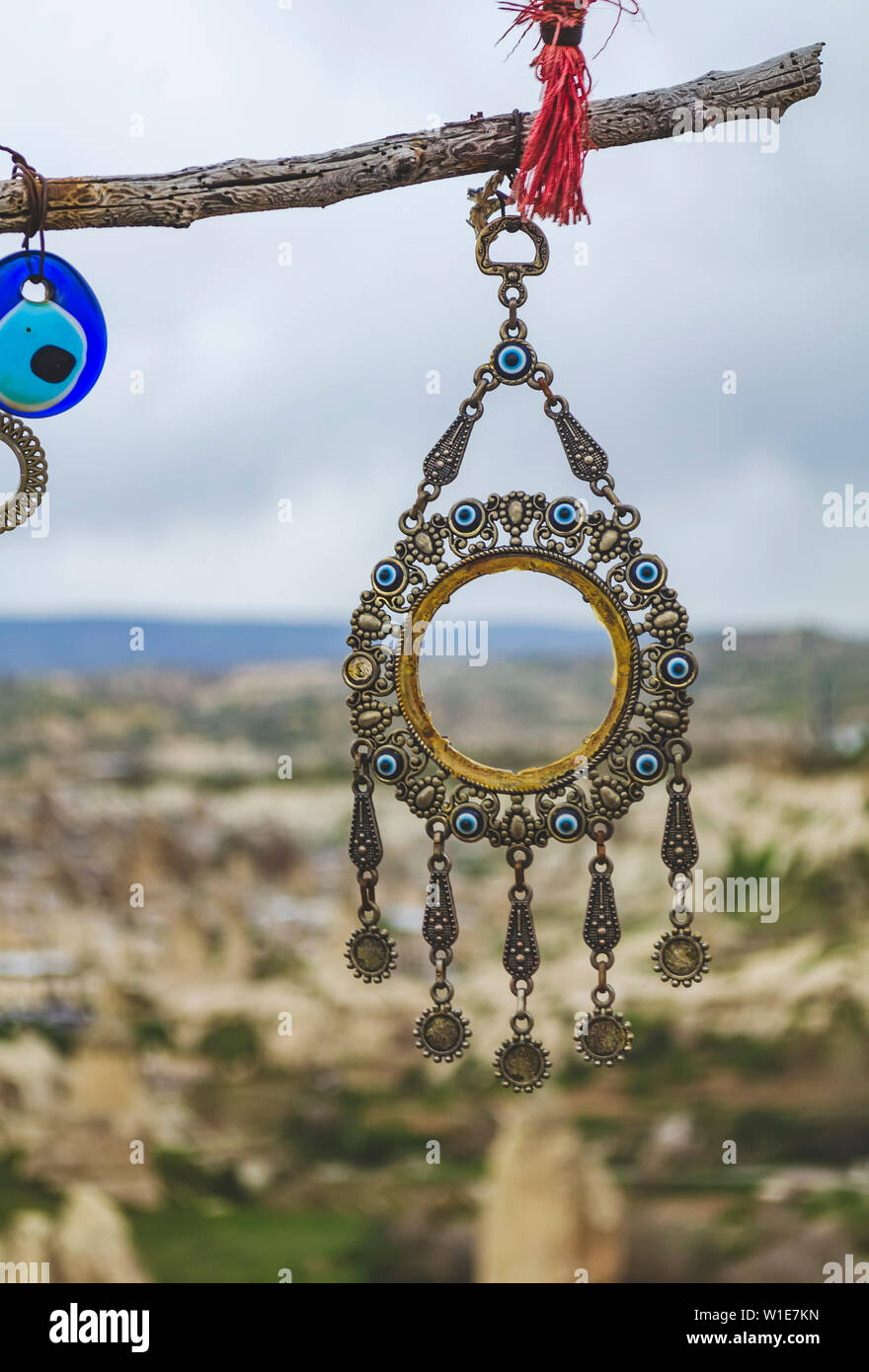 Traditional Turkish charm decoration hangs on a branch against the background of the volcanic landscape of Cappadocia Stock Photo