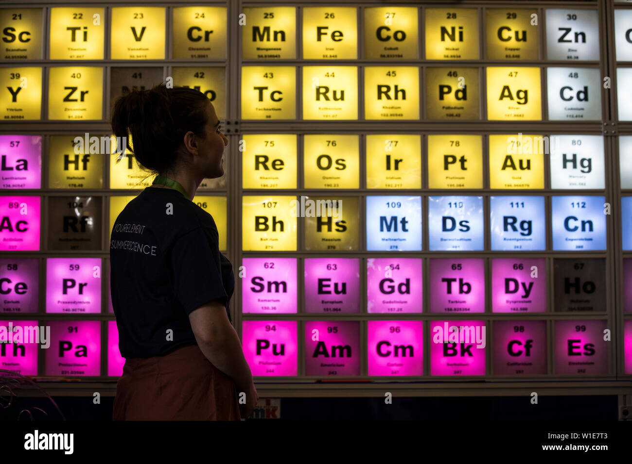 Royal Society Summer Science Exhibition, a young woman looking at an illuminated Periodic Table celebrating the 150th Anniversary, London, UK Stock Photo