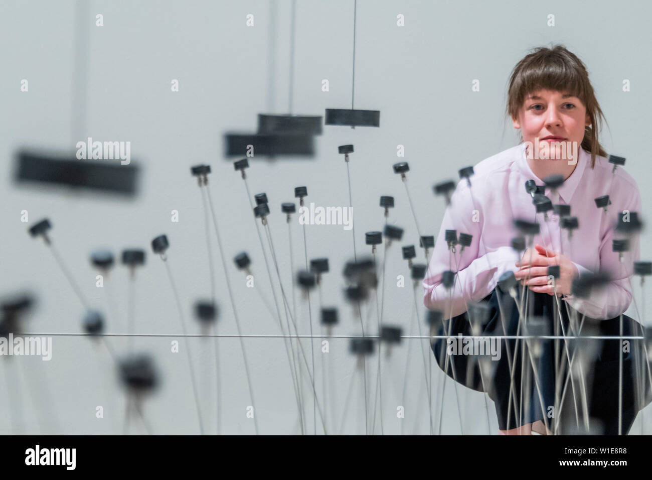 London, UK. 2nd July 2019. Magnetic Fields installation, on display for the first time since the 1970s, in which magnetic pendulums trigger movement from nearly a hundred small sculptures - Takis at Tate Modern. Takis (Panayiotis Vassilakis, b.1925) a sculptor of magnetism, light and sound. It brings together over 80 works and is Takis’ largest exhibition in the UK to date. Credit: Guy Bell/Alamy Live News Stock Photo