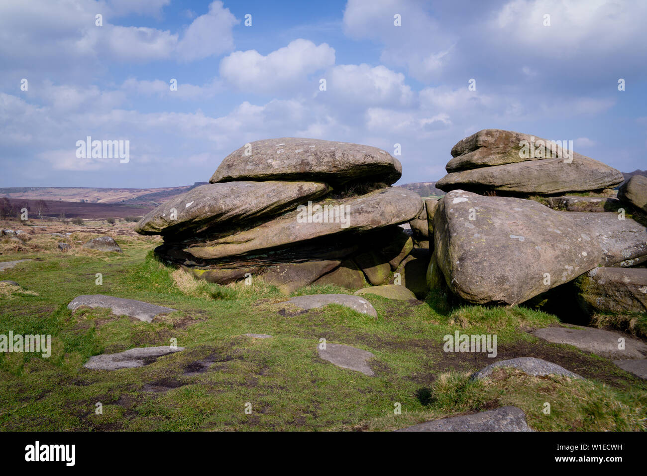 A pile of millstone grit rocks or boulders at Over Owler Tor in the Peak District, overlooking moorland Stock Photo