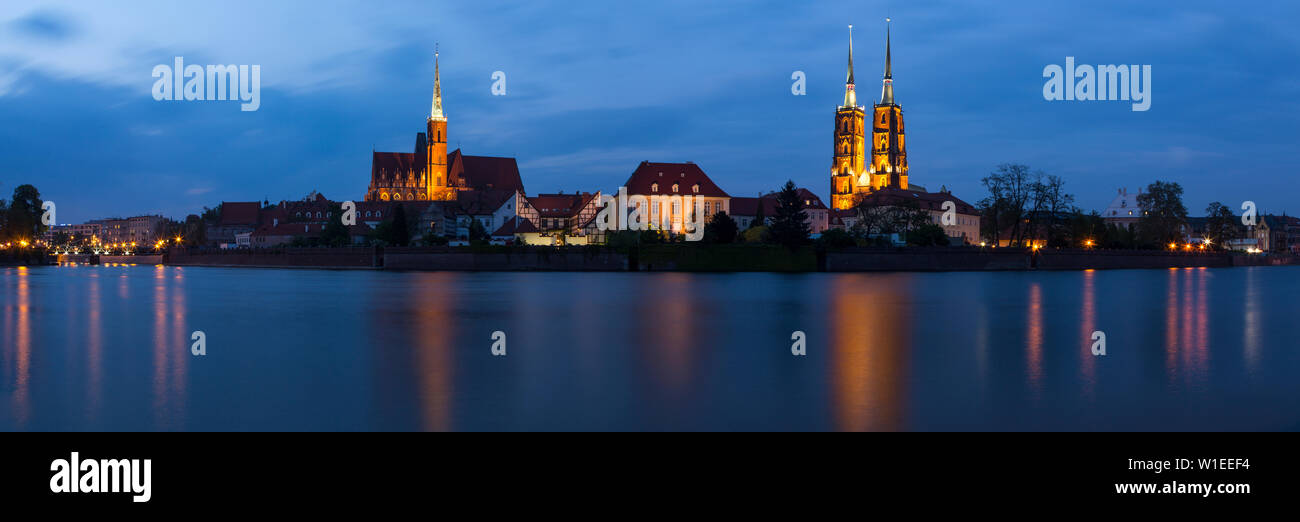 Night photography of two images in one photo: panorama of a church and cathedral including reflections in the river Odra, Wroclaw, Poland Stock Photo