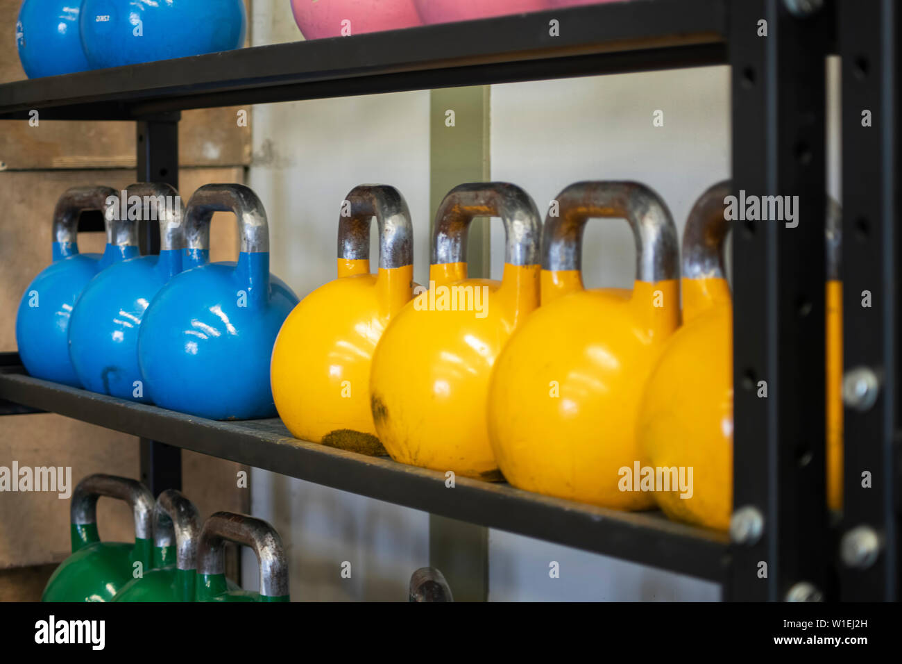 Heavy weight sets of kettlebell on iron racks at the gym used for