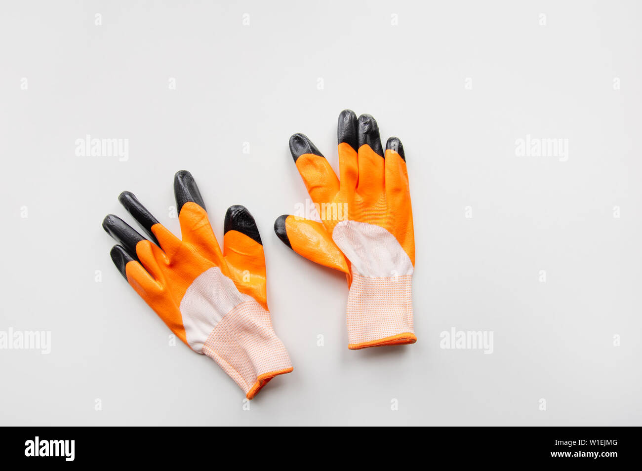 Orange work gloves on white background. housework concept. Stock Photo