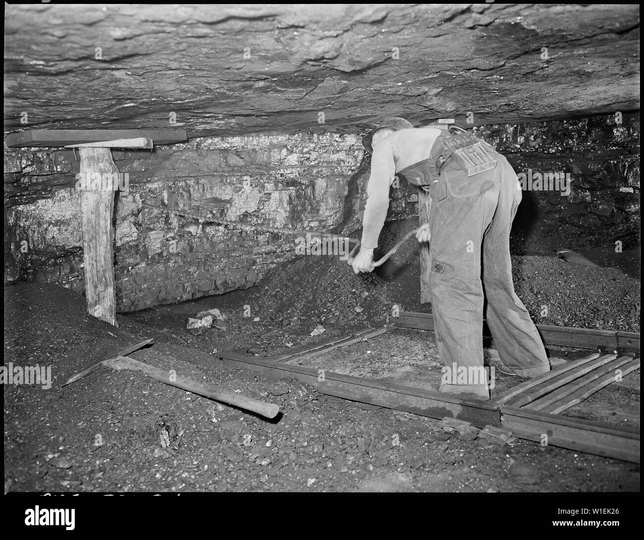 Harry Fain, coal loader, drills coal with hand auger. Powder charges ...