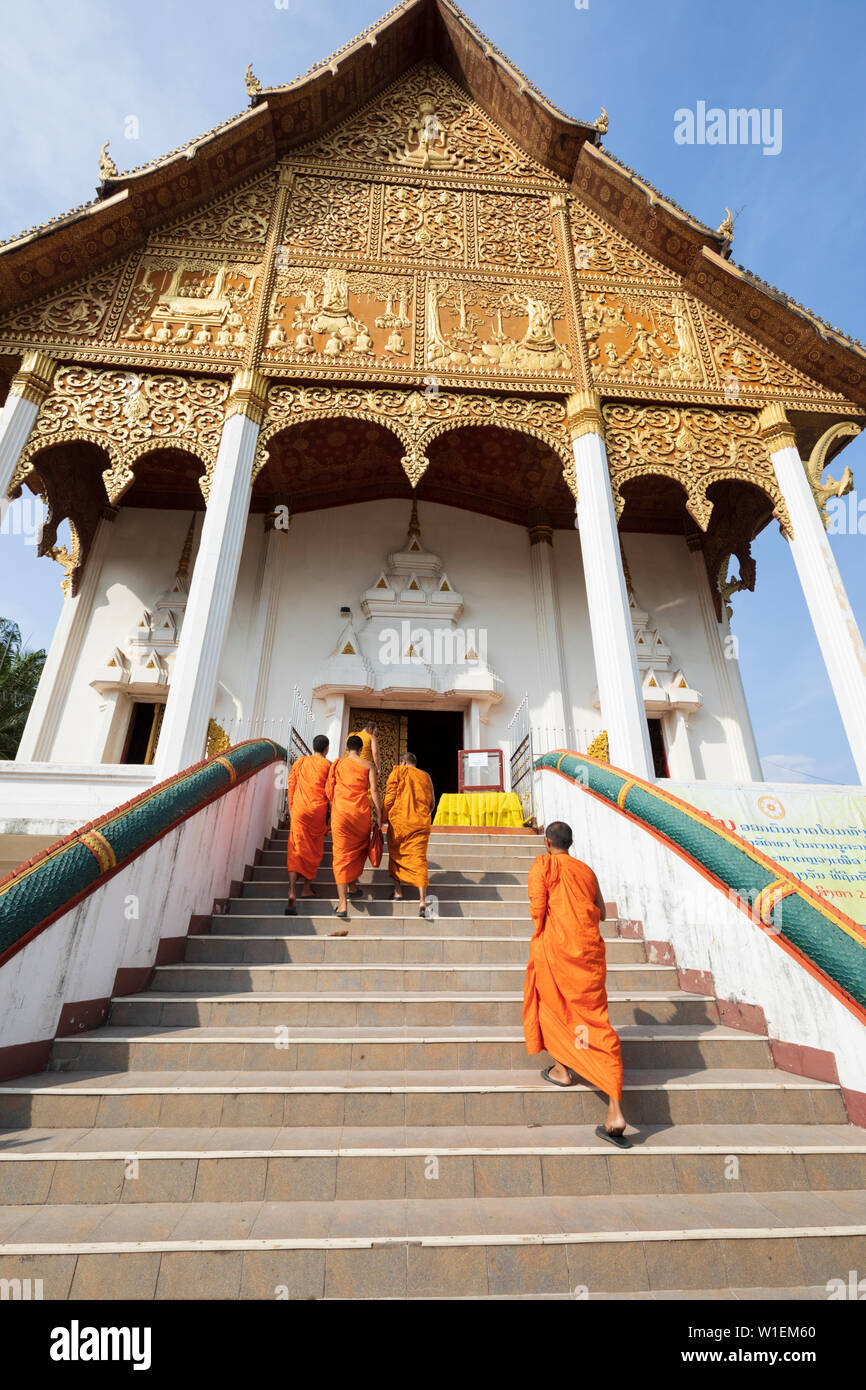 Buddhist monks climbing stairs to a temple at the Pha That Luang, Vientiane, Laos, Indochina, Southeast Asia, Asia Stock Photo