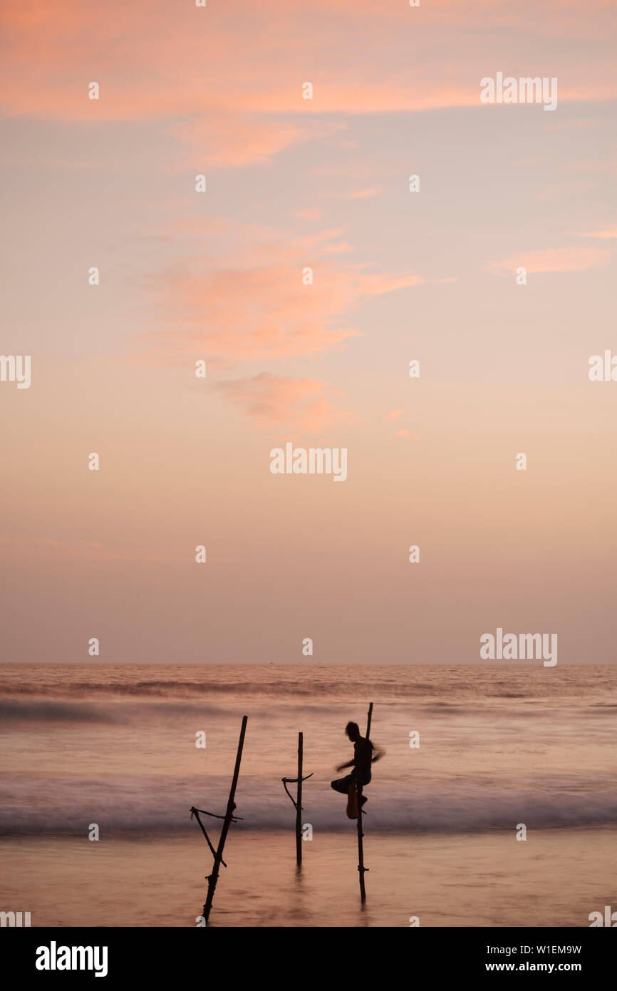 Stilt Fishermen at dusk, Weligama, South Coast, Sri Lanka, Asia Stock Photo