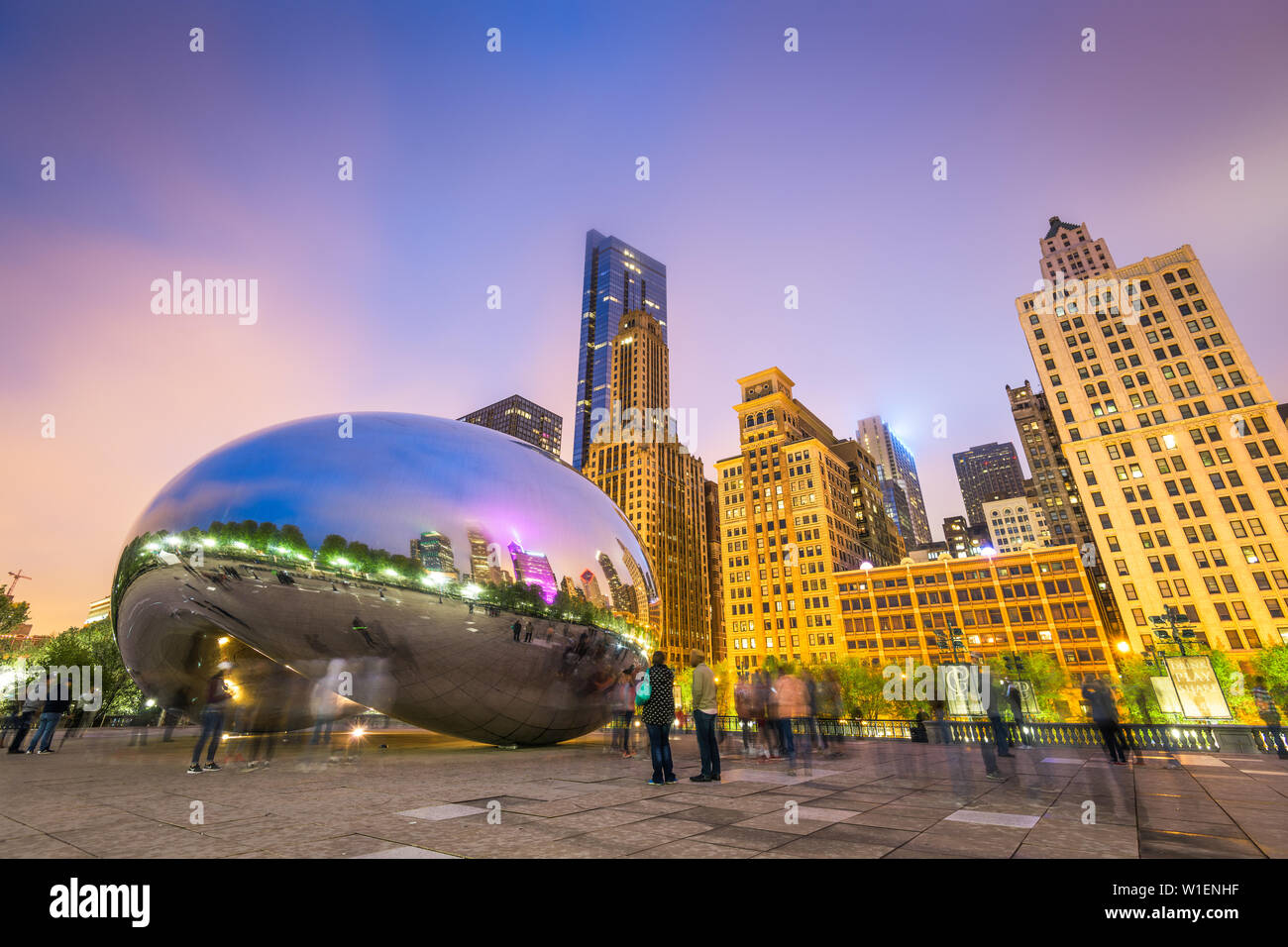 CHICAGO - ILLINOIS: MAY 12, 2018: Tourists visit Cloud Gate in Millennium Park in the late evening. Stock Photo