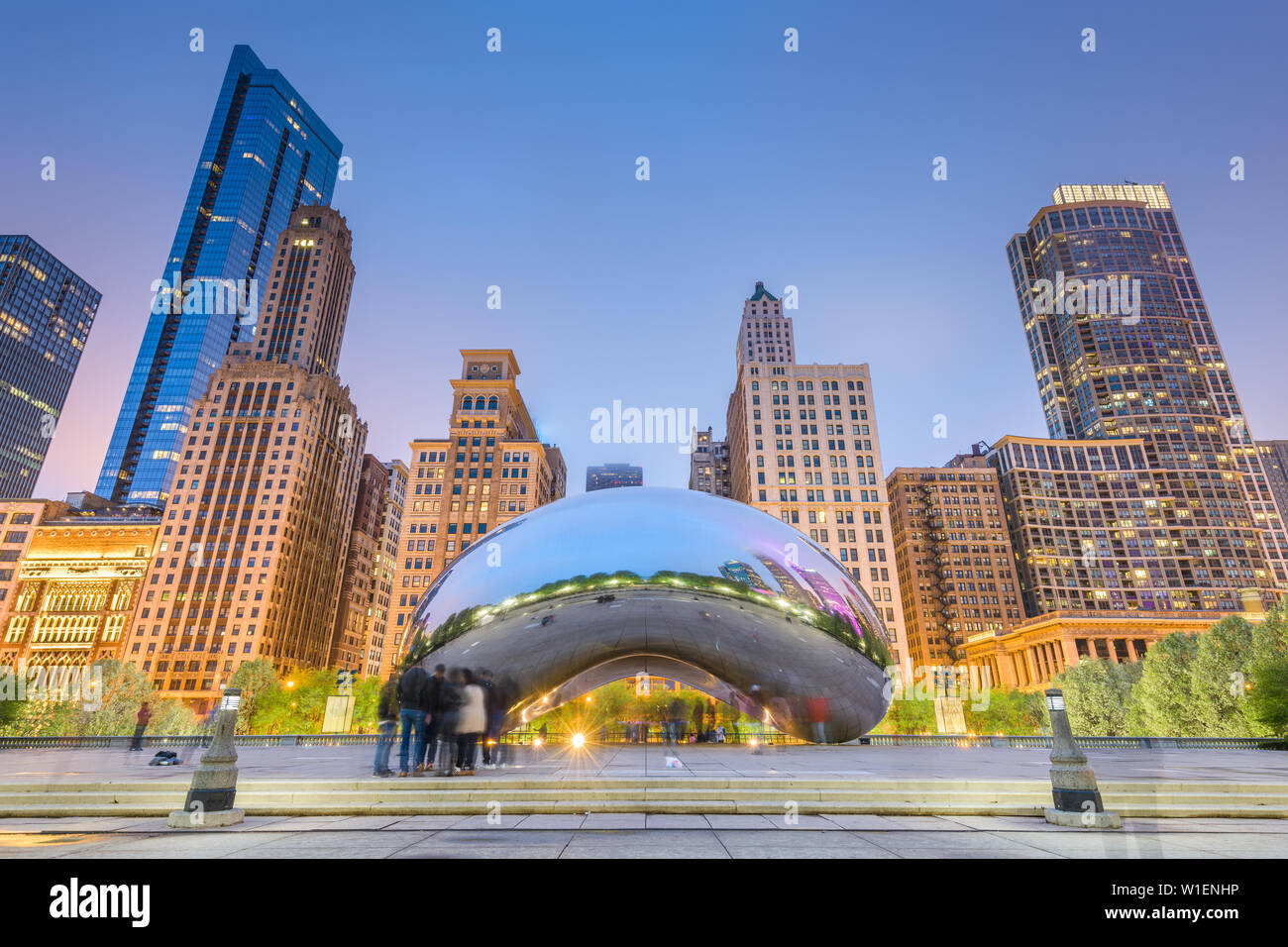 CHICAGO - ILLINOIS: MAY 12, 2018: Tourists visit Cloud Gate in Millennium Park in the late evening. Stock Photo