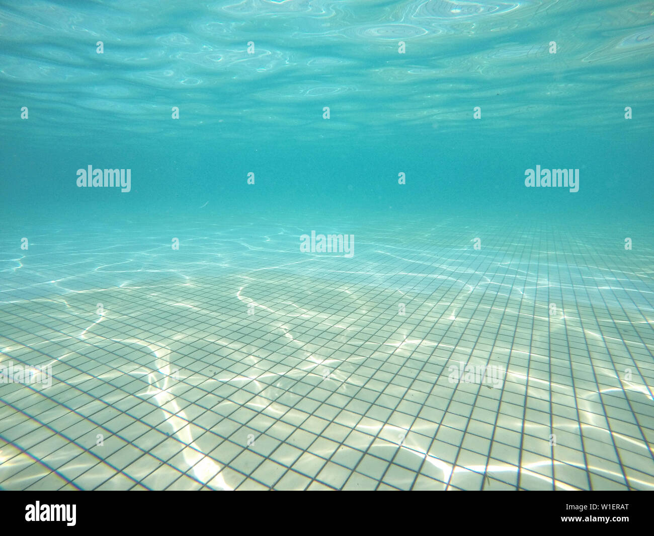 underwater view of swimming pool floor with sunlight reflections. concept of leisure activities and summer Stock Photo