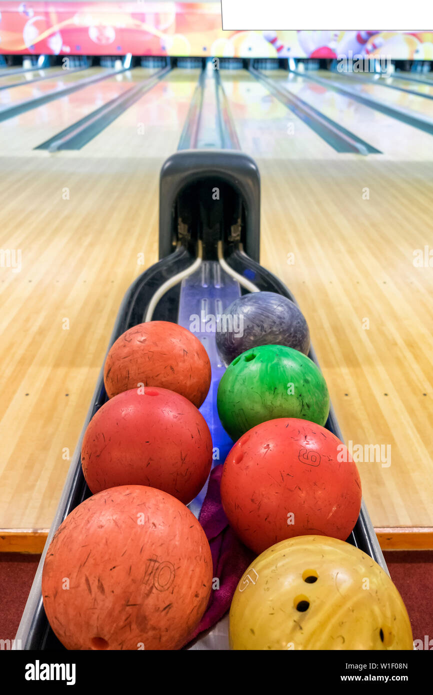 Multi colored bowling balls on base Stock Photo