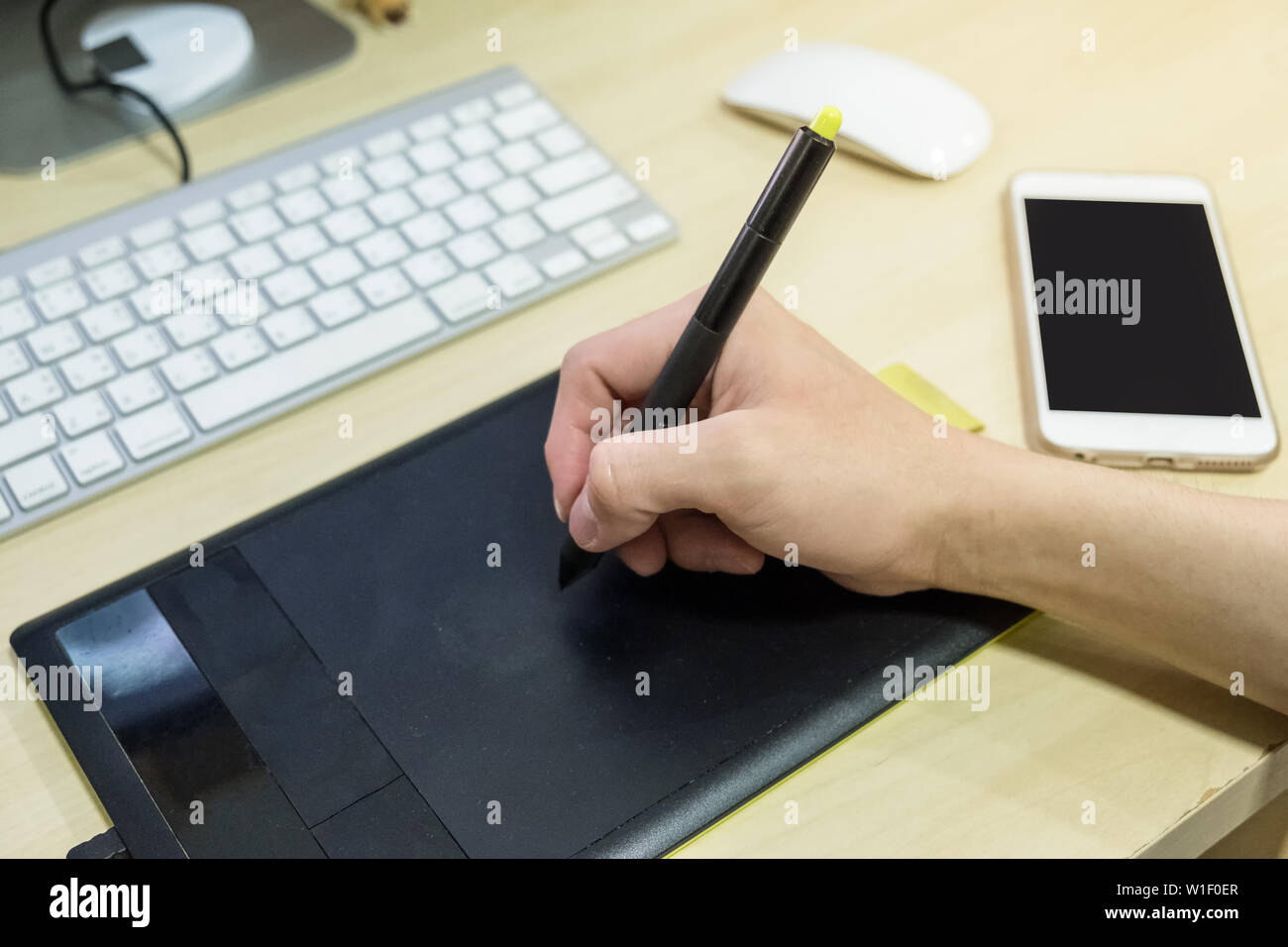 Hand using graphic tablet with smartphone on desk at workplace Stock ...