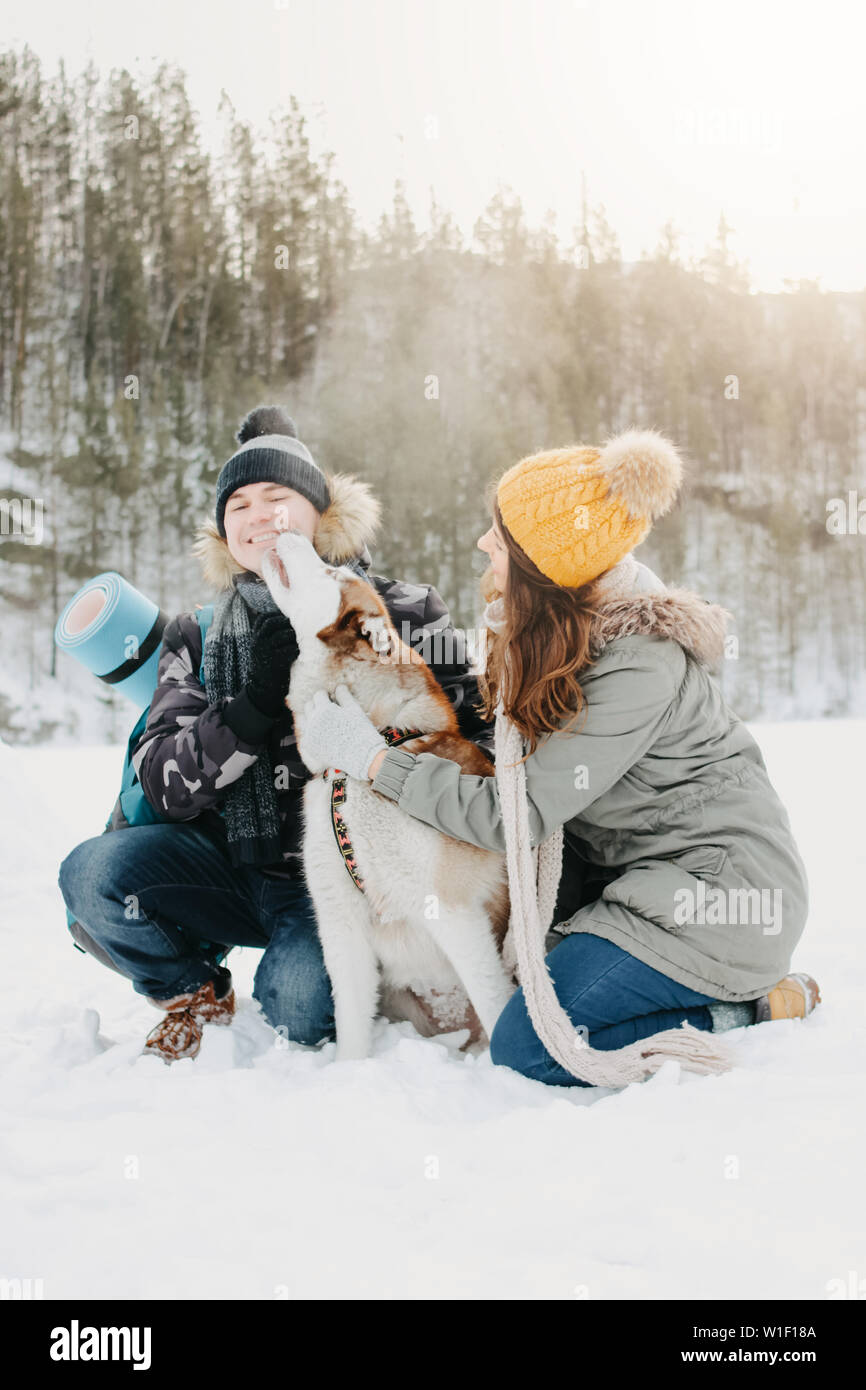 The happy couple with dog haski at forest nature park in cold season ...