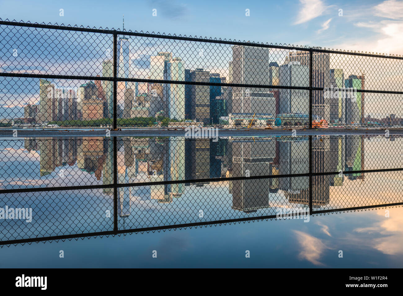 New York, New York, USA city skyline of Lower Manhattan on the New York harbor through fencing. Stock Photo