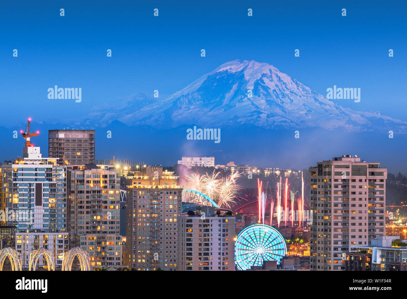 Seattle, Washington, USA downtown skyline with Mt. Rainier and a fireworks show below. Stock Photo