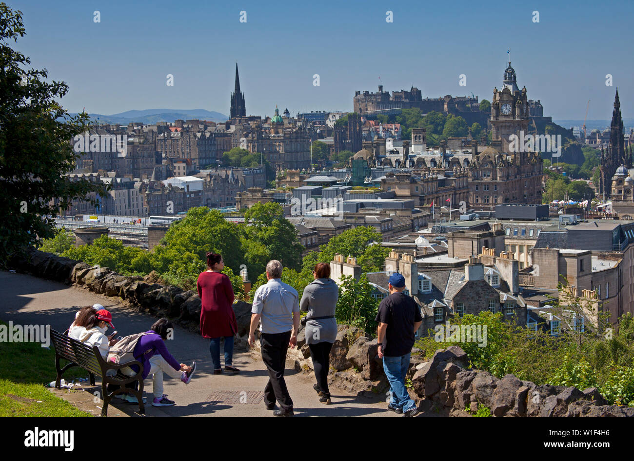 Tourists looking over Edinburgh city centre towards the castle from Calton Hill, Scotland, UK Stock Photo