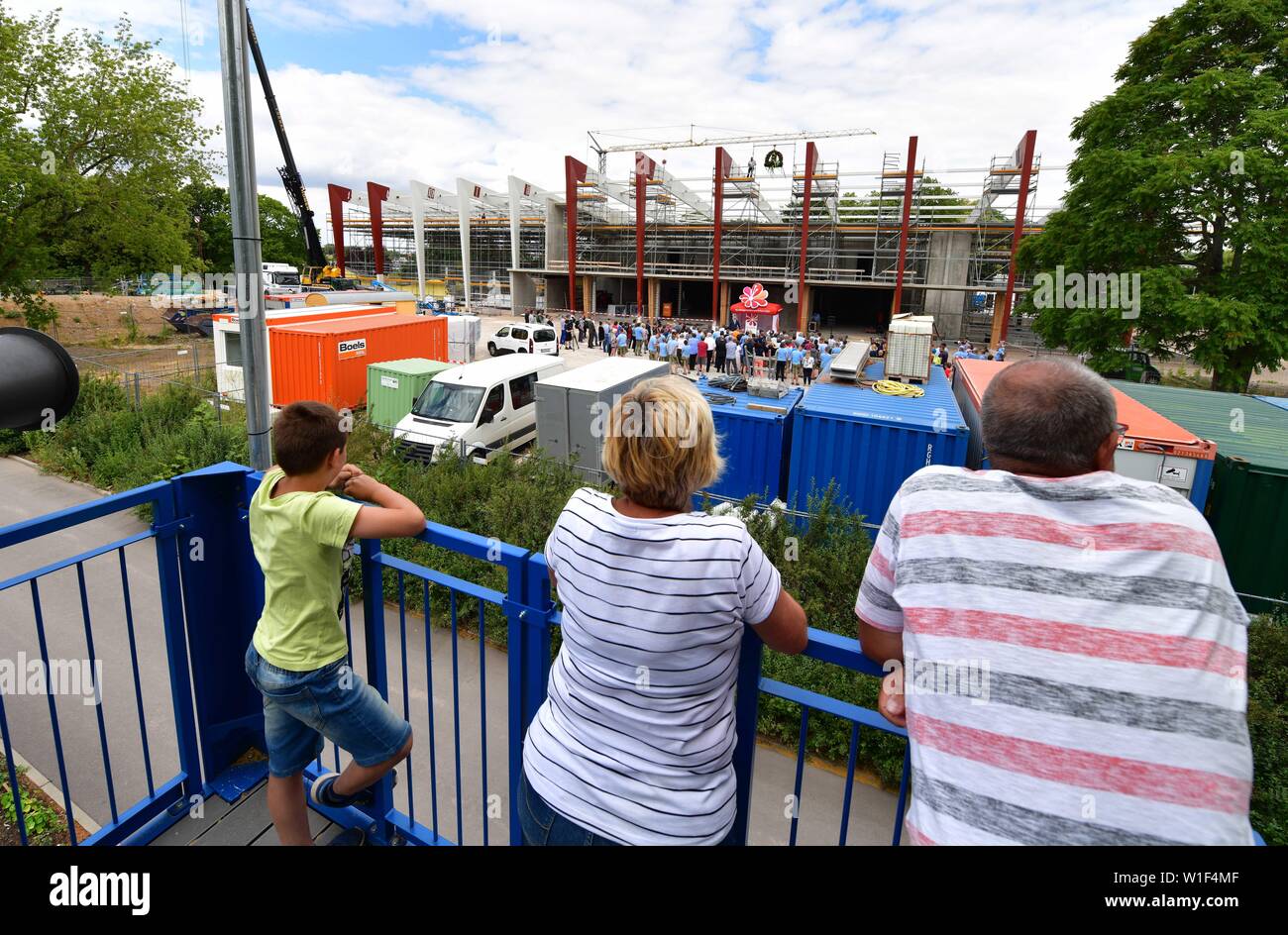 Erfurt, Germany. 02nd July, 2019. Three visitors of the egapark stand on a viewing platform and look at the topping-out ceremony of the future desert and jungle house 'Danakil'. The more than 2000 square metre Klimahaus is to become the attraction of the 2021 Federal Horticultural Show. In two interconnected buildings, the climatic conditions of a desert and a jungle are simulated. Credit: Martin Schutt/dpa-Zentralbild/dpa/Alamy Live News Stock Photo