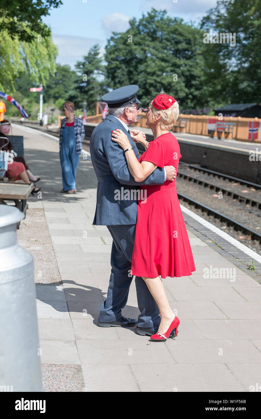 Kidderminster, UK. 29th June, 2019. Severn Valley Railways 'Step back to the 1940s' gets off to a fabulous start this weekend with costumed re-enactors playing their part in providing an authentic recreation of wartime Britain. A smartly-dressed couple in 1940's fashion are dancing together on the platform of a vintage railway station in the morning sunshine. Credit: Lee Hudson Stock Photo