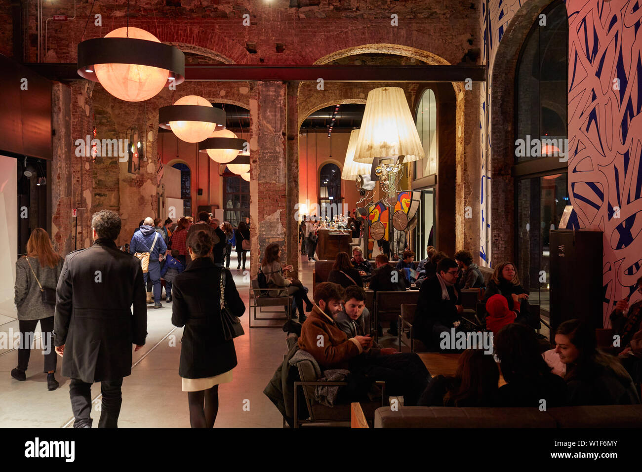 Ogr, Officine Grandi Riparazioni cafe interior with people, evening in Turin, Italy. Stock Photo