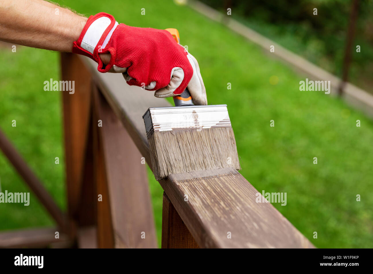 restoring wood protective paint on outdoor patio railings Stock Photo