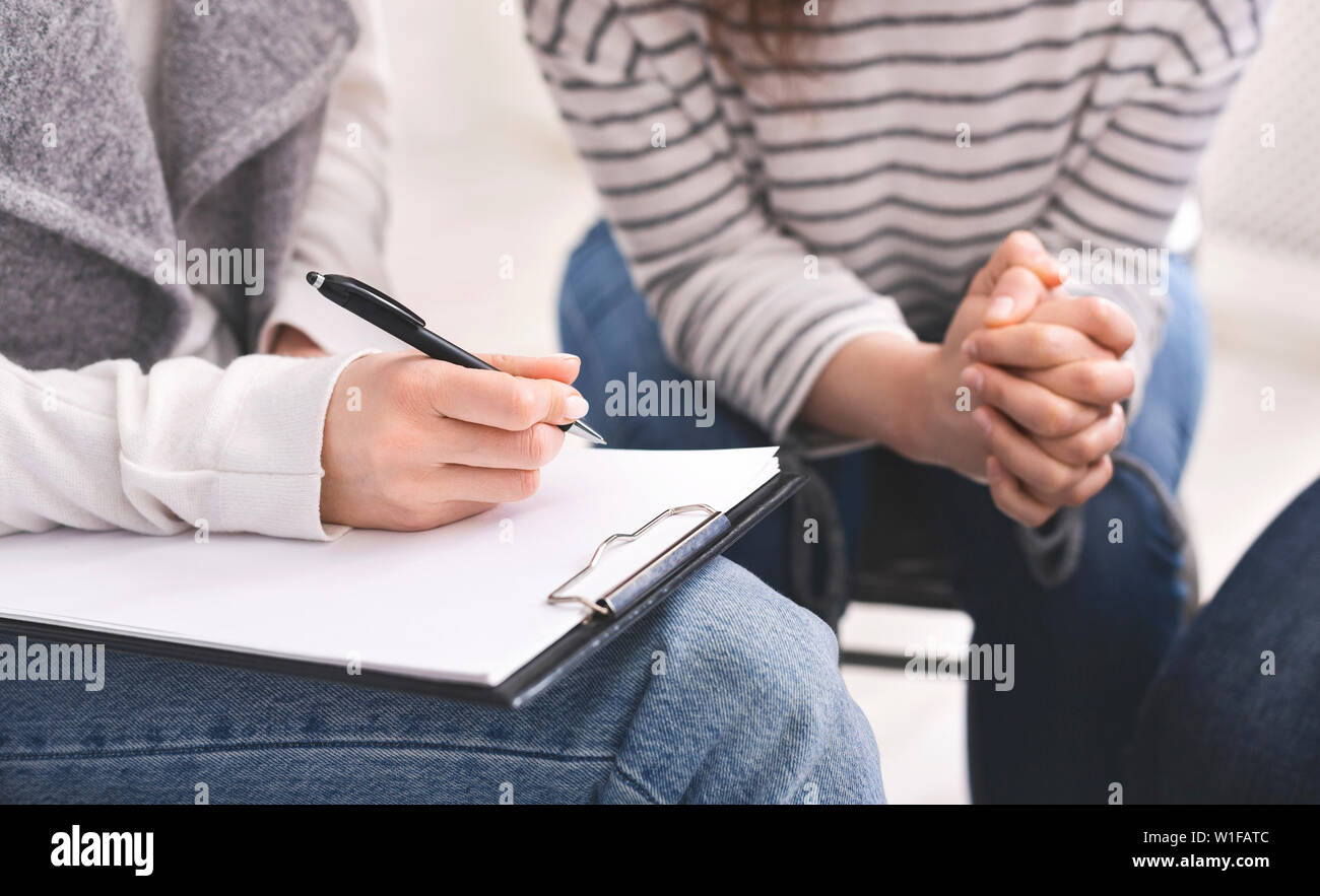 Psychologist listening to addicted woman and noting down problems Stock ...