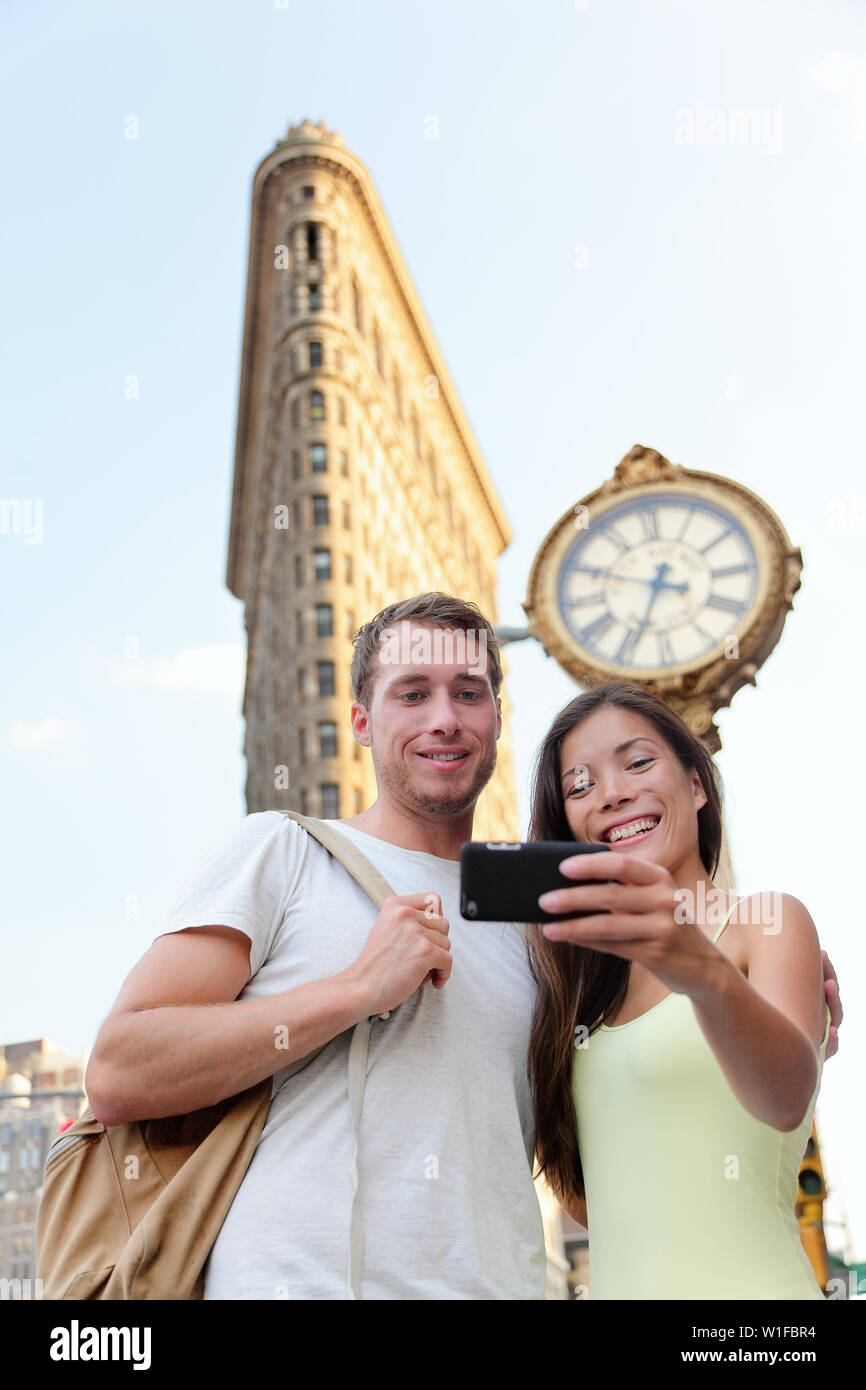 New York couple taking tourist selfie Flatiron NYC. Young adults taking