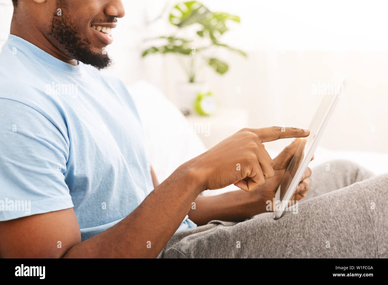 Relaxed casual man using tablet in bed Stock Photo