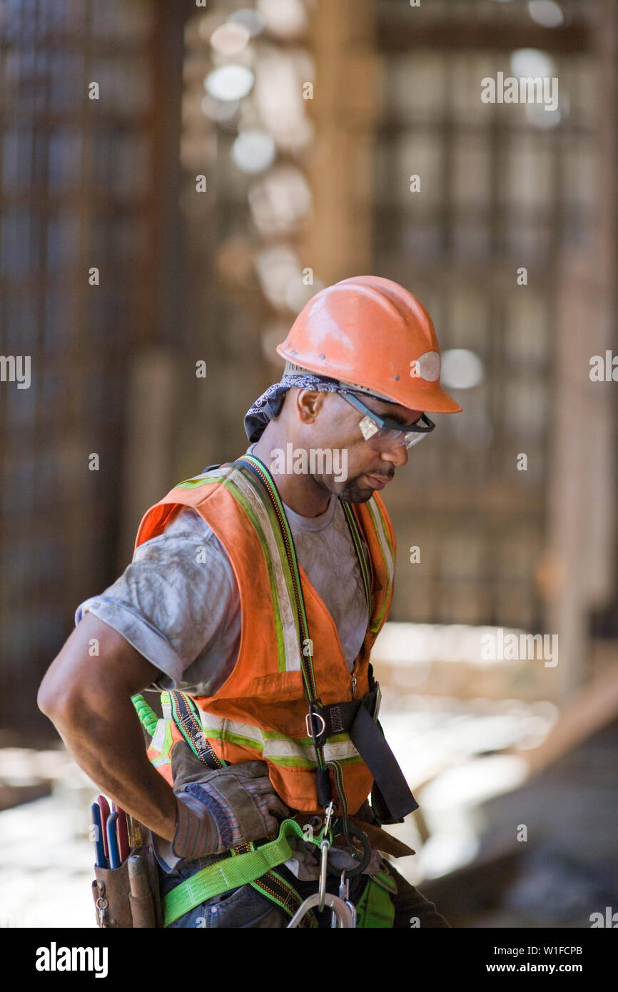 Dirty mid-adult construction worker wearing a helmet and hi-visibility ...