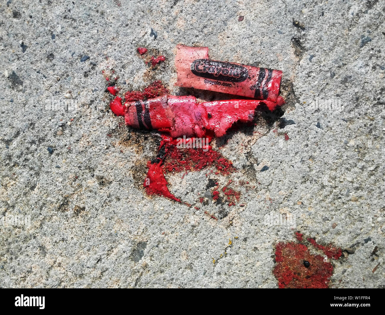 A melted Crayola brand crayon on the sidewalk in New York on Saturday, June 29, 2019. (© Richard B. Levine) Stock Photo