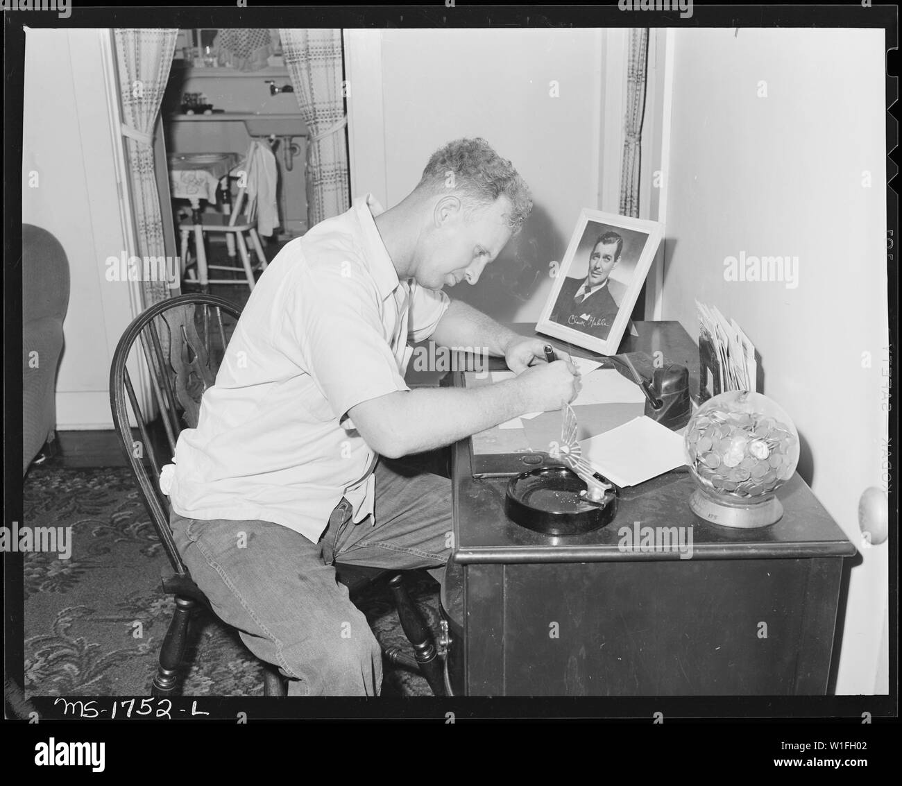 James Jasper, motor brakeman, writes a letter in his home in company housing project. Koppers Coal Division, Kopperston Mine, Kopperston, Wyoming County, West Virginia. Stock Photo