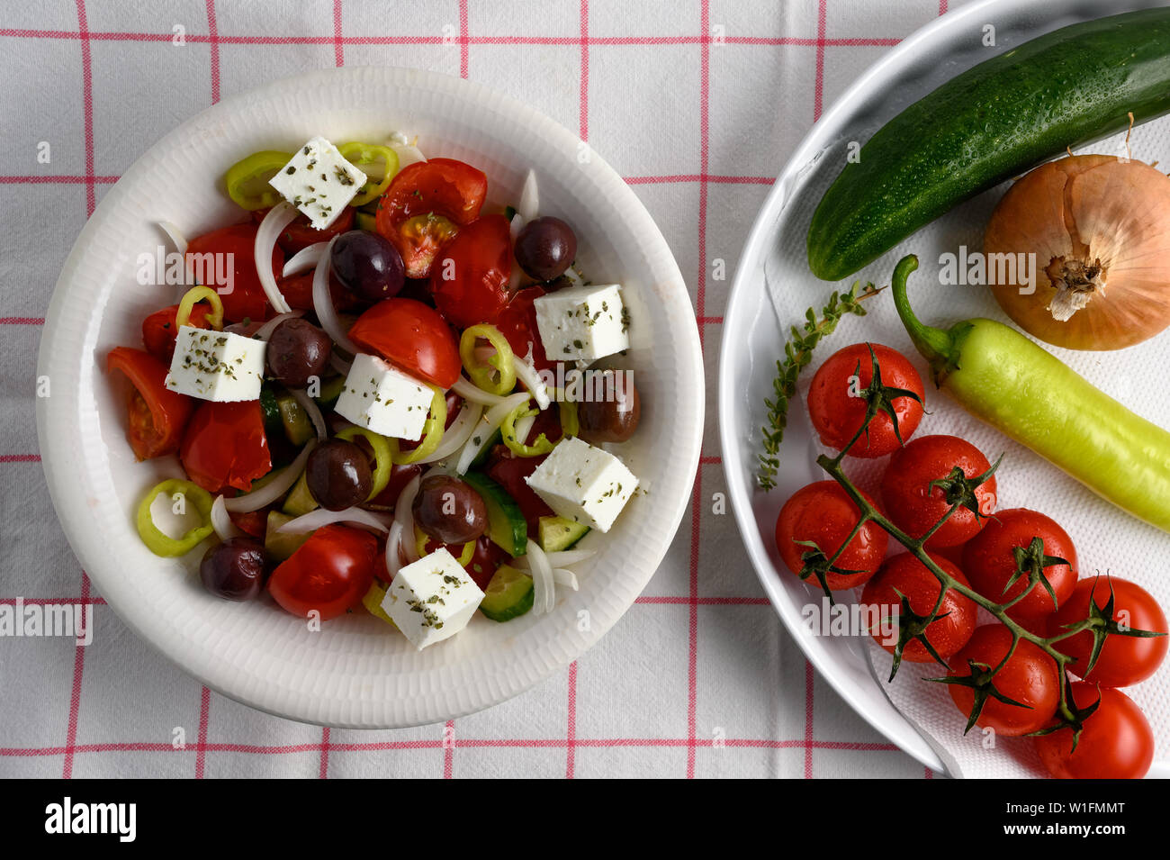 Traditional greek salad in white plate on white table linen Stock Photo