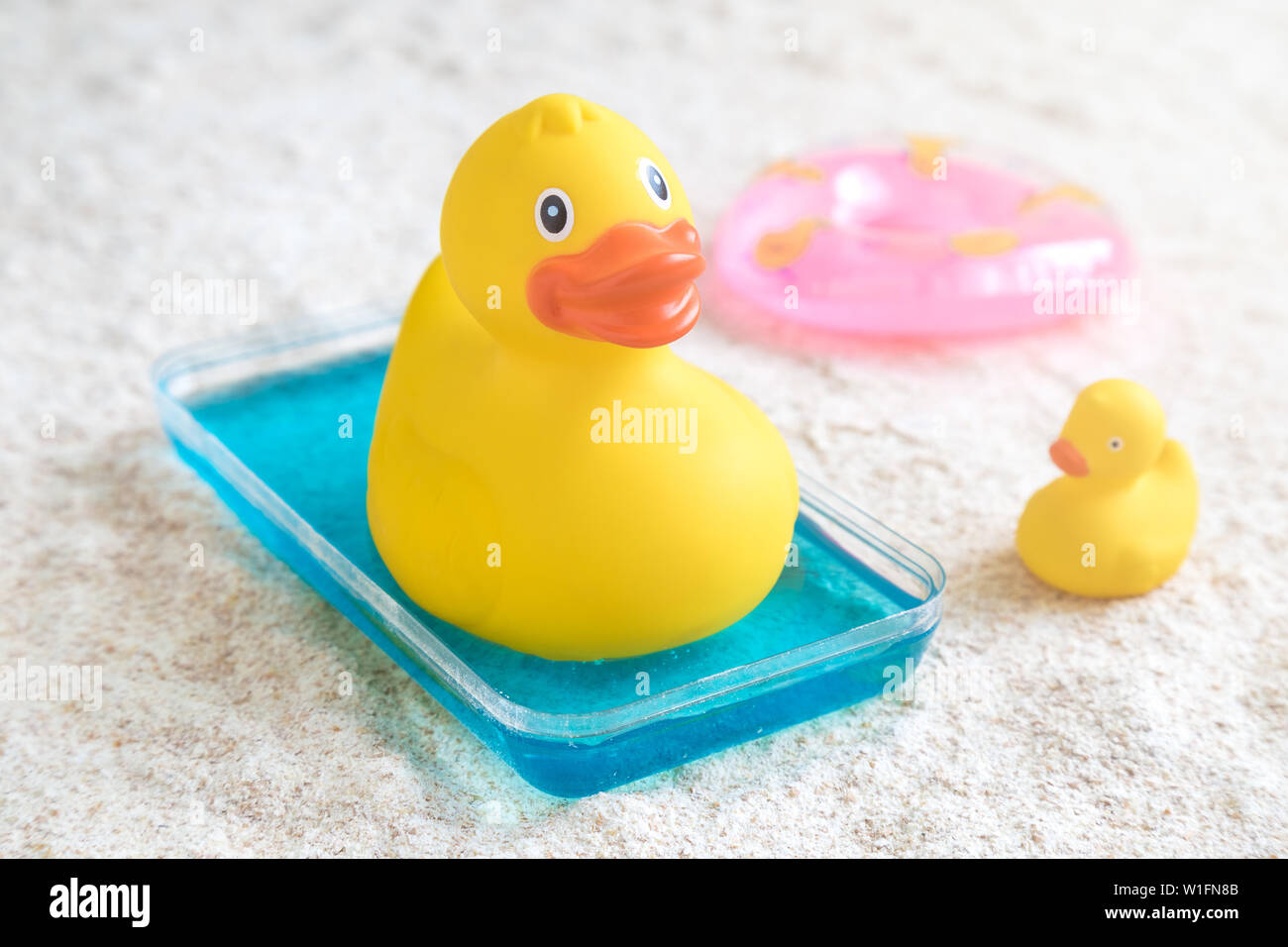 Rubber duck in small kids swimming pool on the beach minimal creative