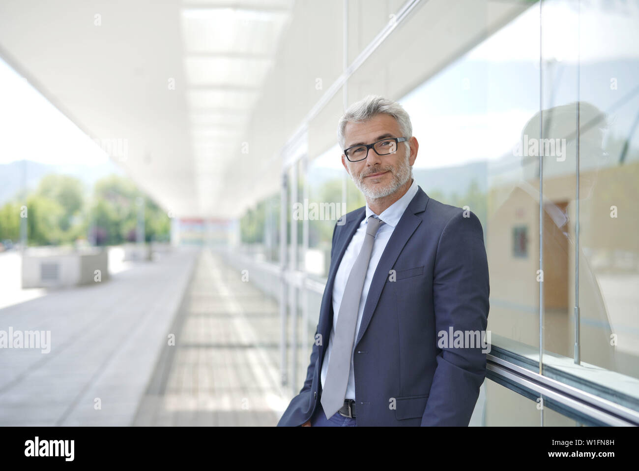 Portrait of corporate businessman outside contemporary office building Stock Photo