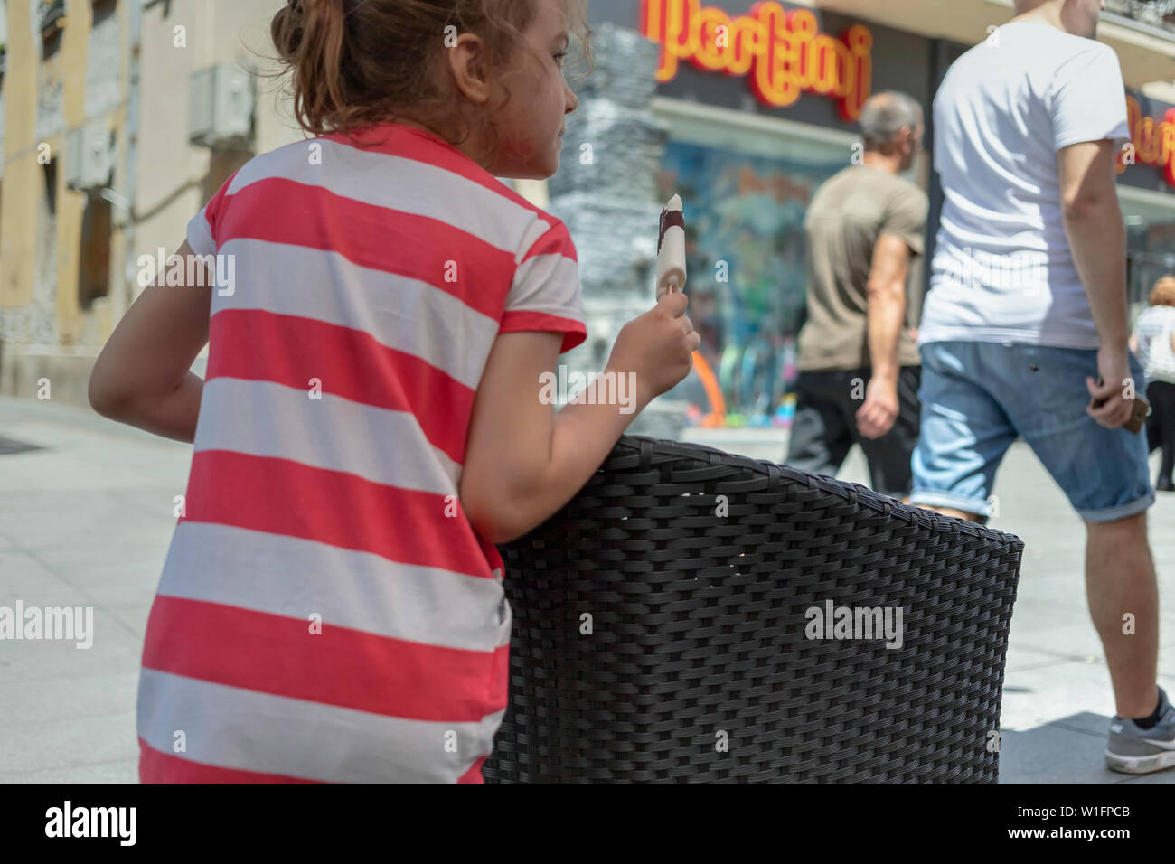 Belgrade, Serbia June 28th 2019: Young girl eating chocolate ice cream bar on the street in Zemun Stock Photo