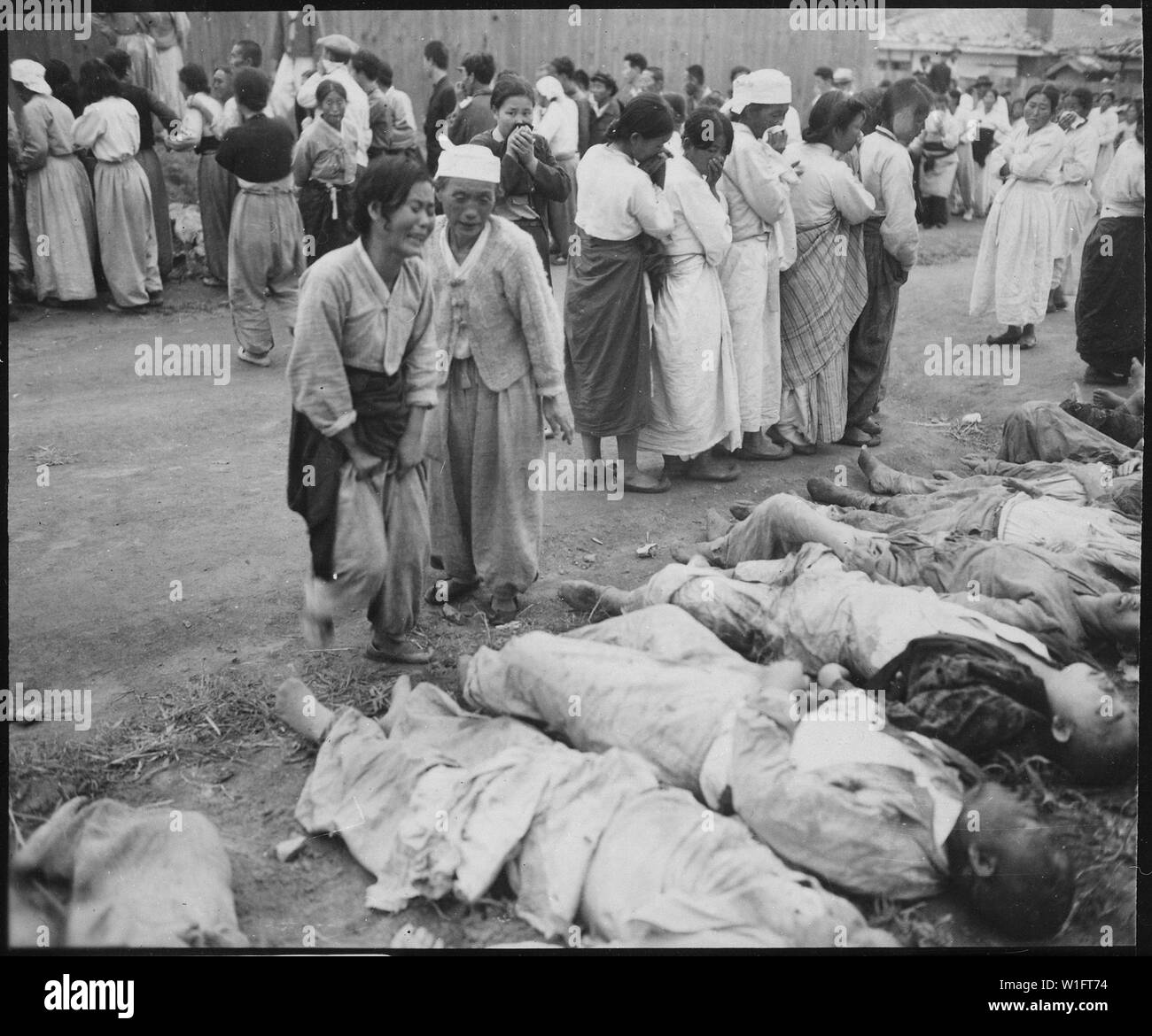 Koreans from Hamhung identify the bodies of some 300 political prisoners who were killed by the North Korean Army by being forced into caves which were subsequently sealed off so that they died of suffocation.; General notes:  Use War and Conflict Number 1508 when ordering a reproduction or requesting information about this image. Stock Photo