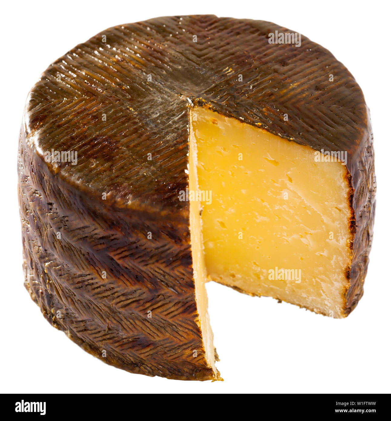 Wheel of famous hard sheep cheese Manchego with cut slice. Isolated