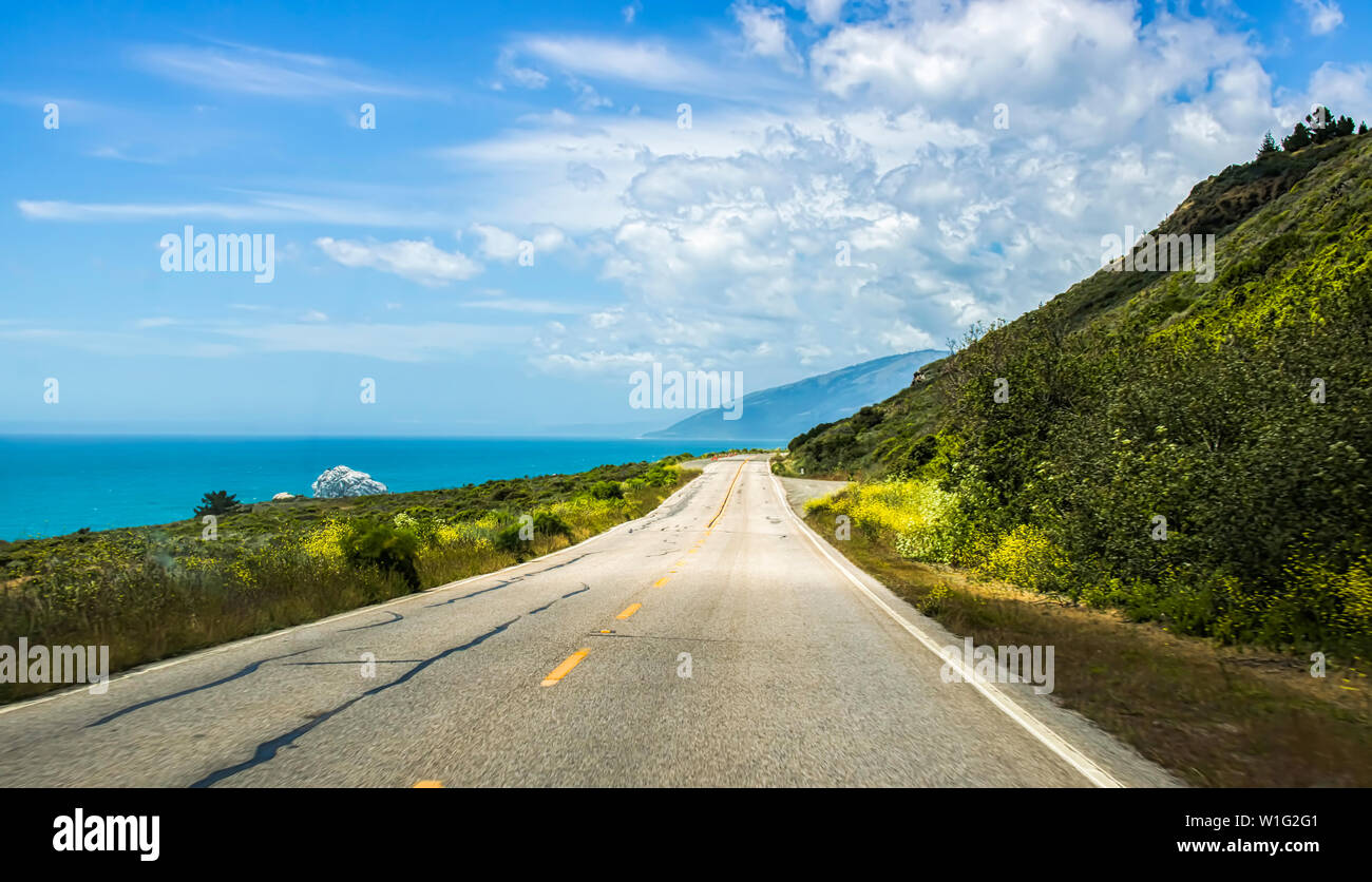 Highway along coast with spring flowers and ocean along edge on California Highway 1 Stock Photo