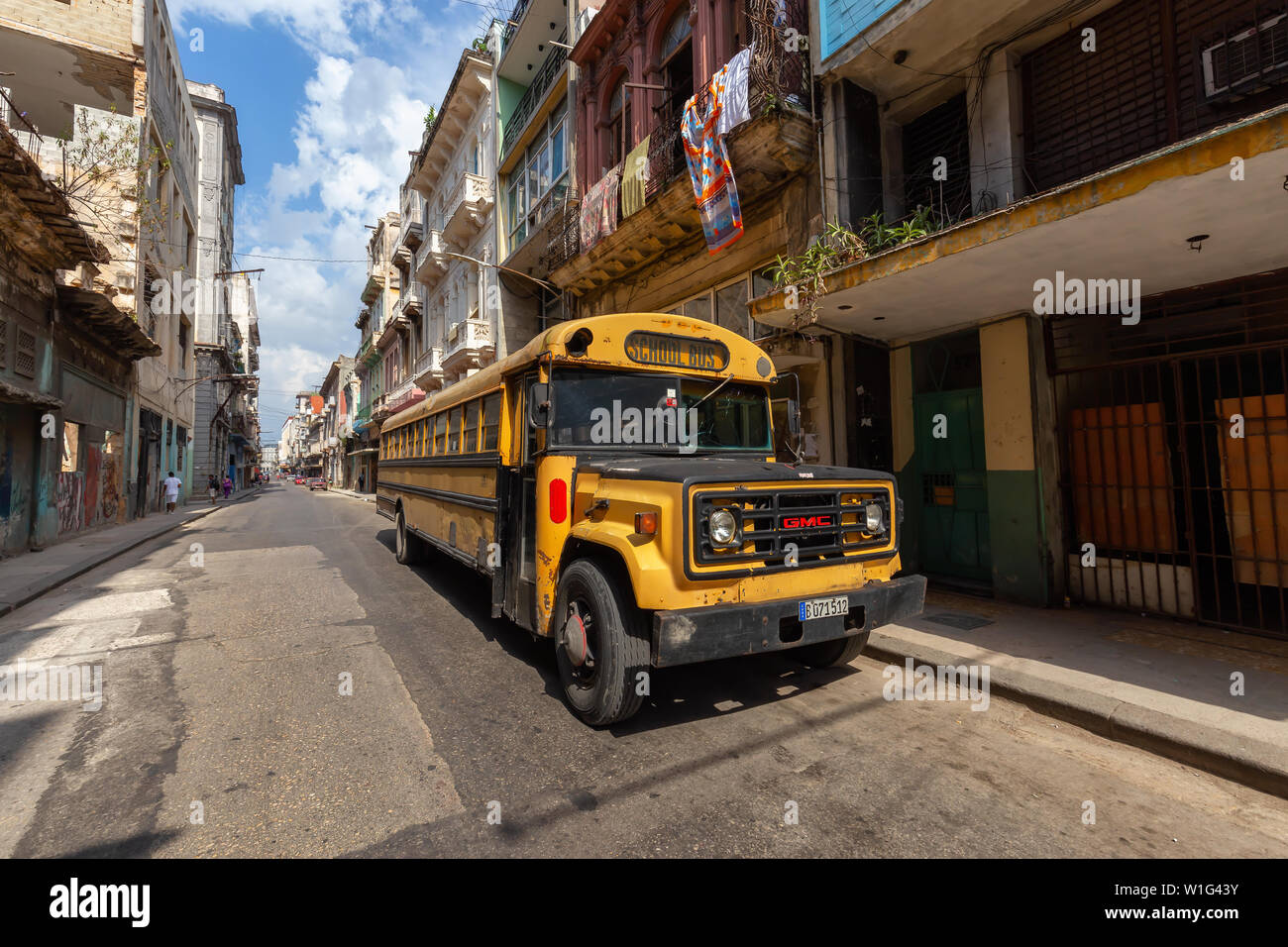 Havana, Cuba - May 14, 2019: Yellow School Bus in the streets of the Old Havana City, Capital of Cuba, during a bright and sunny day. Stock Photo