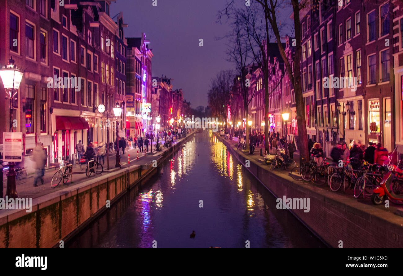 Typical landscape of Amsterdam: tourists, bikes, canals, rivers, buildings, lights, night, cheerfulness, bustle, agitation. We are here in the Red Qua Stock Photo