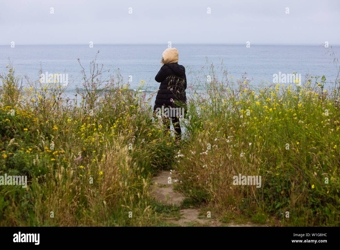 Woman back facing the ocean in Pigeon Point Light Station State Historic Park, Pescadero, California, USA Stock Photo