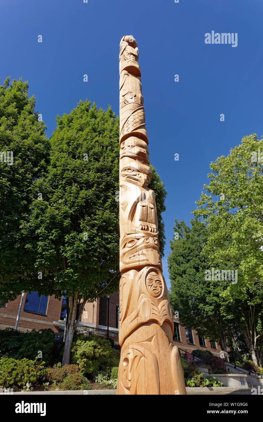 New Kwakiutl style Reconciliation totem pole carved by Xwalacktun and James Harry outside the Vancouver School Board building, Vancouver, BC, Canada Stock Photo