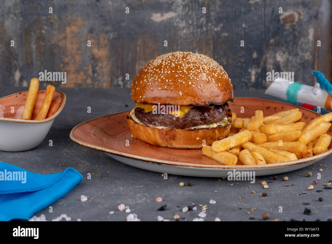 Le Fils A Papa Burger Craft beef burger with sesame bun and french fries on stone background. .  Modern fast food lunch Stock Photo - Alamy