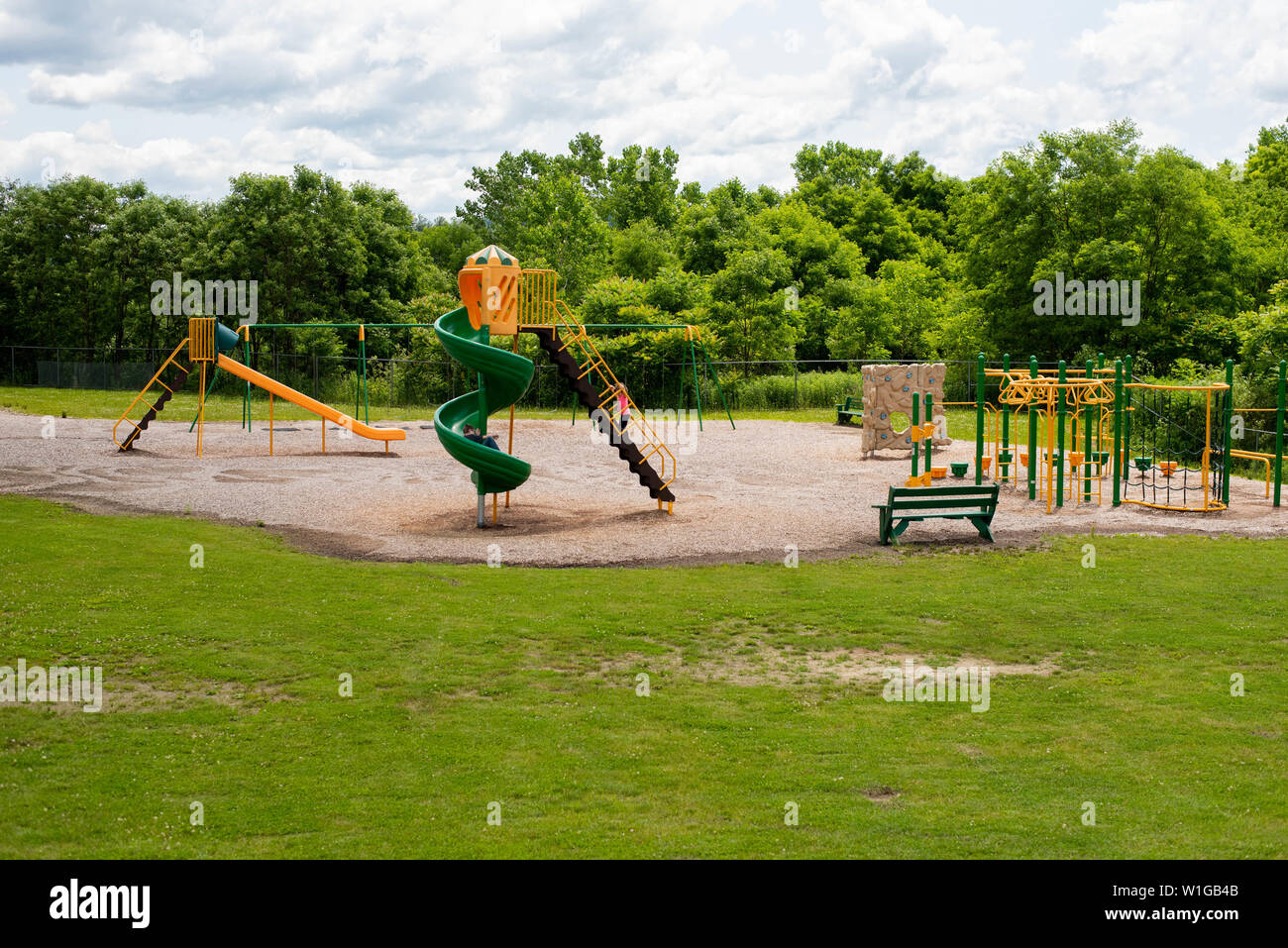 Children playing on playground equipment on a summer day. Stock Photo